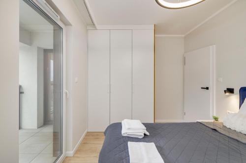 a bedroom with a bed and a glass wall at Sen Krasnala by FuzjaAparts in Wrocław