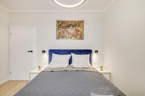 a bedroom with a bed and a painting on the wall at Sen Krasnala by FuzjaAparts in Wrocław