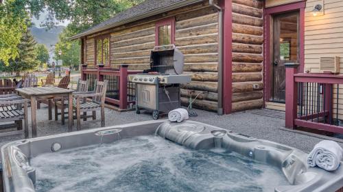a hot tub with a grill next to a log cabin at Harris House in Breckenridge