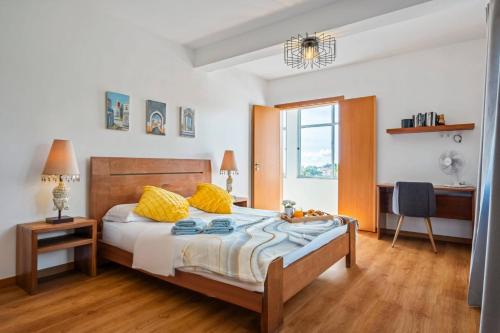 a bedroom with a bed with yellow pillows at Tornos in Funchal