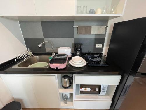 a small kitchen with a sink and a microwave at icondo มิตรภาพซอย4 in Nakhon Ratchasima
