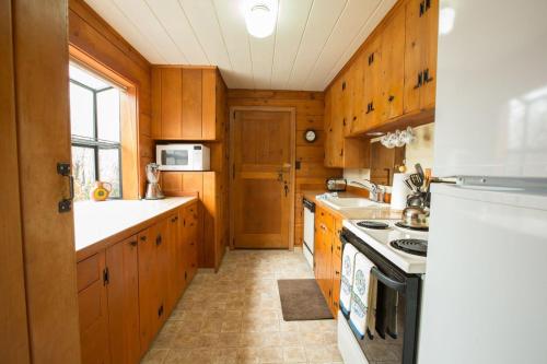 Una cocina con gabinetes de madera y un horno de estufa. en Mirror Pond bungalow, en Bend