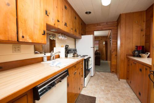 a kitchen with wooden cabinets and a white refrigerator at Mirror Pond bungalow in Bend