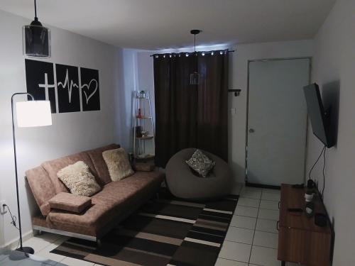 a living room with a couch and a television at Departamento Ganges in León