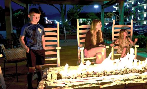 a young boy standing in front of a fire pit at Arbors at Island Landing Hotel & Suites in Pigeon Forge