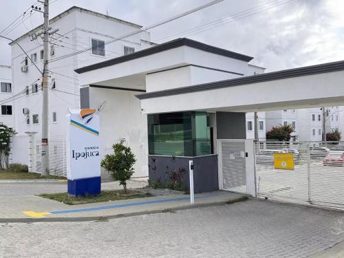 a white building with a sign in front of it at Apê moderno com Ar, Wi-Fi, máquina de lavar, garagem e portaria 24h- completo e confortável! in Caruaru