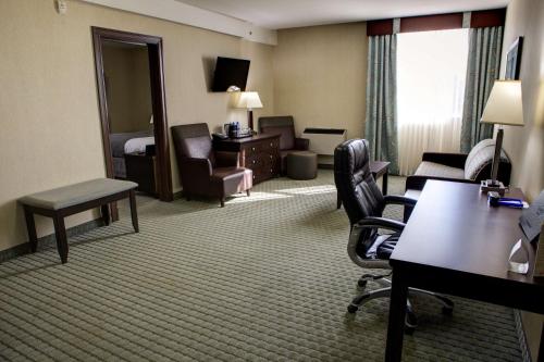 a hotel room with a bed and a living room at Coast Lethbridge Hotel & Conference Centre in Lethbridge