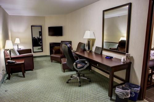 a hotel room with a desk and a mirror at Coast Lethbridge Hotel & Conference Centre in Lethbridge