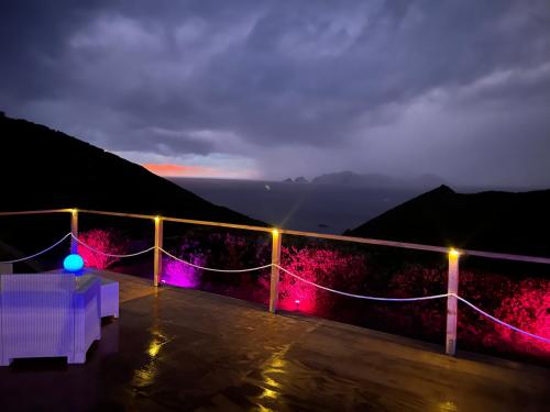 a balcony with a table and lights at night at Palmaria Sky Bubbles Room in Ponza