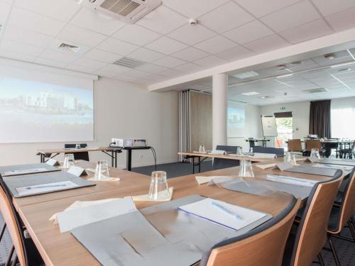 a conference room with a large table and chairs at Hôtel Confort La Rochelle Centre les Minimes in La Rochelle