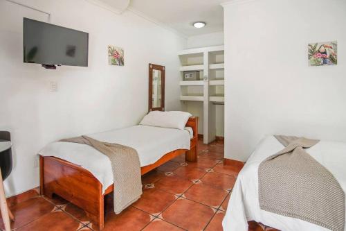 a room with two beds and a flat screen tv at Room C – Perfect Rest in Heredia in San Juan Arriba