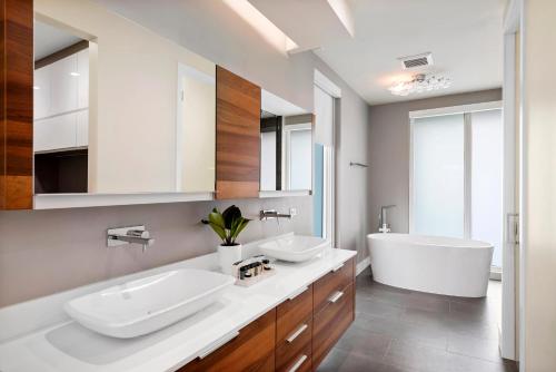 a bathroom with two sinks and a bath tub at Modani Estates in Miami