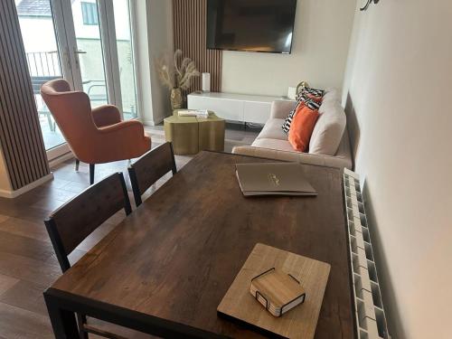 a living room with a table with a laptop on it at Lake View Apartment Modern,stylish,4 beds, balcony in Bowness-on-Windermere
