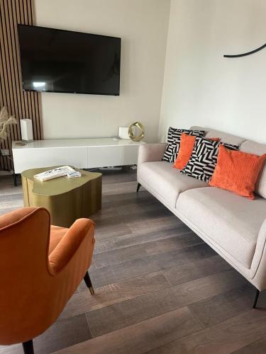 a living room with a couch and a tv on the wall at Lake View Apartment Modern,stylish,4 beds, balcony in Bowness-on-Windermere