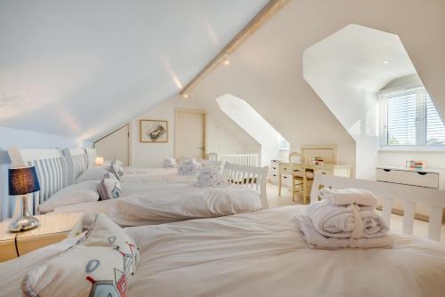 a group of white beds in a room at 5 Bed in Rock oc-m33185 in Padstow
