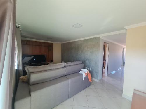 a living room with a couch and a television at CasaMelo in São Pedro da Aldeia