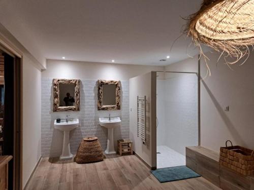 a bathroom with two sinks and two mirrors at La Clef des songes in Lafarre