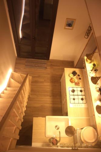a small kitchen with a stove and a staircase at Case Monte Arso -Etna sud est- in Ragalna