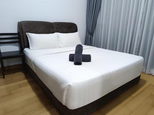 a bed with a black teddy bear sitting on it at The Luxe & Colony Infinitum KLCC by CoupleStay in Kuala Lumpur