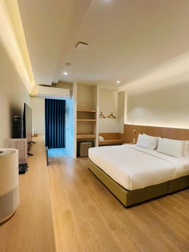a bedroom with a large bed and a desk at Minitel at Hatyai in Ban Khlong Wa