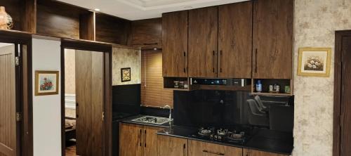 a kitchen with wooden cabinets and a black counter top at 2 bed Stylish Furnished Apartments at Prime Location in Lahore