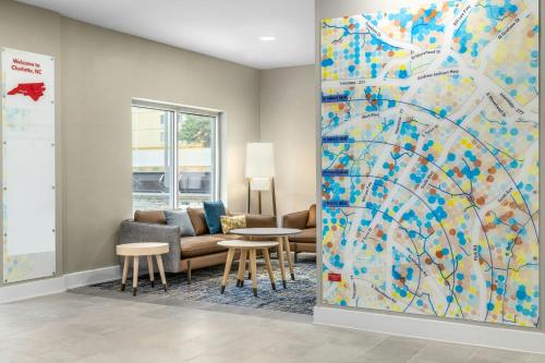 a living room with a large painting on the wall at TownePlace Suites by Marriott Charlotte LoSo Airport in Charlotte