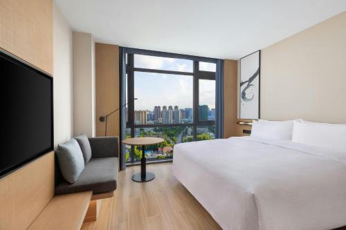 a hotel room with a bed and a large window at Fairfield by Marriott Wuhan Hankou in Wuhan