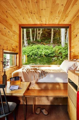 a bed in a wooden room with a window at Postcard Cabins Wild Rose, Outdoor Collection by Marriott Bonvoy in Wild Rose