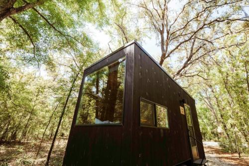 a black tiny house in the woods at Postcard Cabins Wild Rose, Outdoor Collection by Marriott Bonvoy in Wild Rose