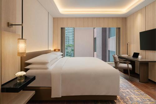 a hotel room with a bed and a desk and a computer at Marriott Executive Apartments Bengaluru UB City in Bengaluru