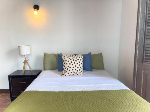 a bedroom with a bed with a green and white comforter at Old San Juan Rentals in San Juan