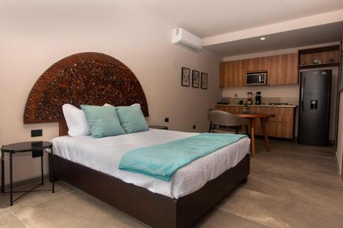 a bedroom with a large bed and a kitchen at Cozy Americana Condo GDL in Guadalajara
