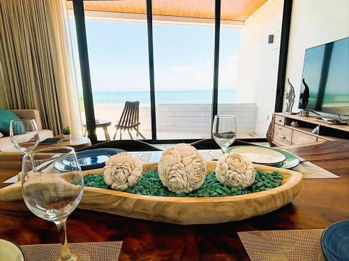 a table with wine glasses and a plate of food at Beachfront 2BR 2BA Condo w Balcony, Ocean Views in Puerto Morelos