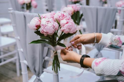 a person is holding a vase of pink flowers at Garner Hotel Elmshorn by IHG in Elmshorn