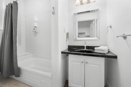 ケベック・シティーにあるSuite Belleの洗面台とシャワー付きの白いバスルーム