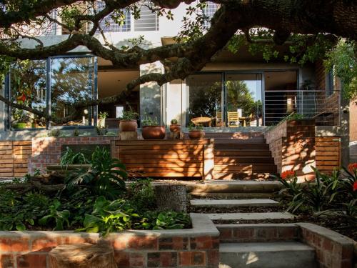 a house with glass doors and stairs in front at Whalesong Lodge in Gansbaai