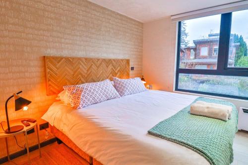 a bedroom with a bed with a large window at HOM I 2D2B Piscina Jacuzzi Estacionamiento Privado in Puerto Varas