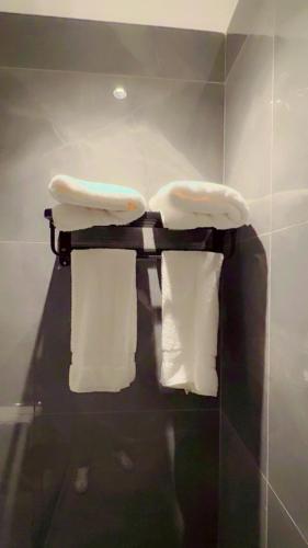 a towel rack with three towels and towels in a bathroom at سكون للاجنحة الفندقية in Baghdad