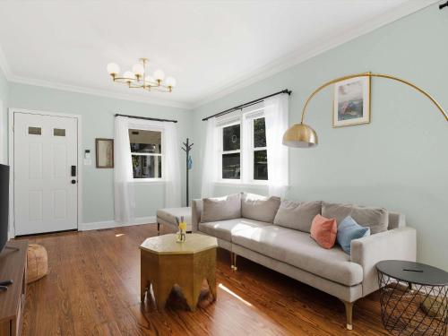 un soggiorno con un divano e un tavolo di Bright & Spacious 3BR Cottage Minutes to DC a Brentwood