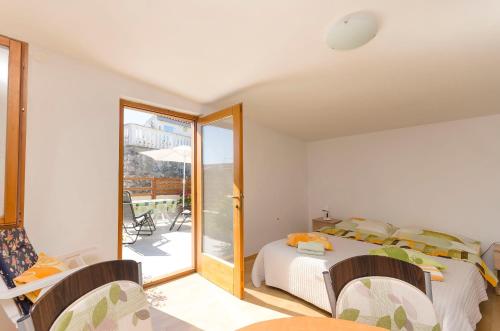 a bedroom with a bed and a sliding glass door at House Hidden Beauty in Tribunj