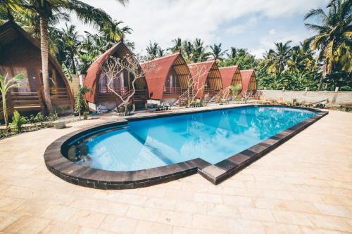 a swimming pool in front of a house at Island Beach Bungalow in Gili Trawangan
