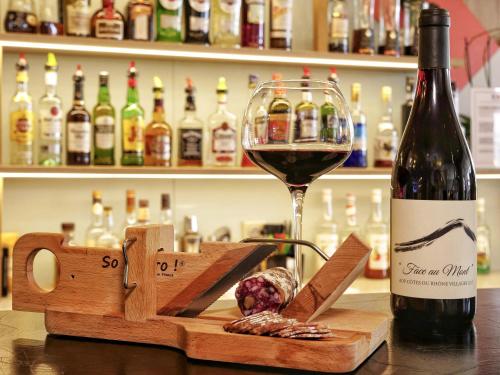 a bottle of wine next to a glass of wine at Mercure Annemasse Porte De Genève in Gaillard
