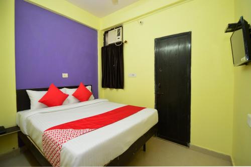 een slaapkamer met een groot bed met rode kussens bij Hotel O Reyansh Galaxy in Kota