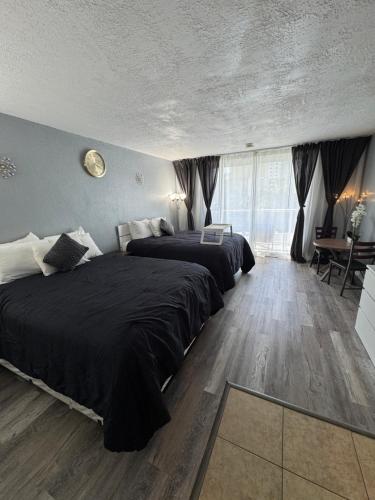 a bedroom with two beds and a table and a window at Miami Sunny Isles Beach Ocean Front Resort Condo with balcony Pool, Beach,Gym,Valet Parking in Sunny Isles Beach