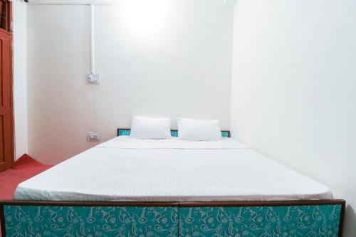 a bed with two pillows on it in a room at Hotel O Dp Bar in Rāmpur
