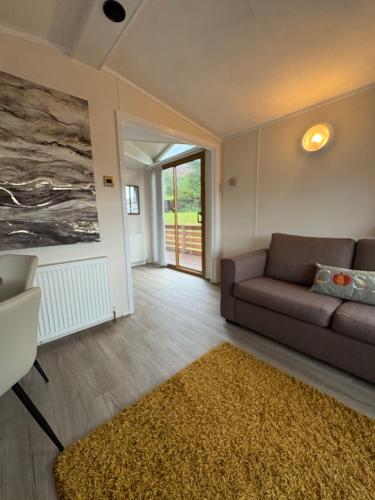 a living room with a couch and a rug at Cosy Caravan by the sea in Cairnryan