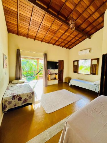 a bedroom with two beds and a large window at Family Guest House in Ilha de Boipeba