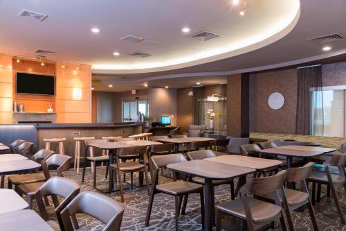 a restaurant with tables and chairs and a bar at SpringHill Suites Midland in Midland