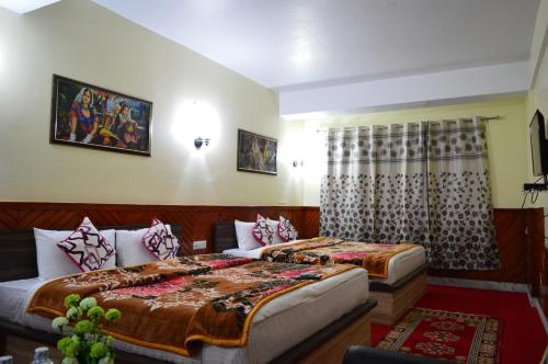 a hotel room with two beds and a window at Hotel Golden Sunrise & Spa in Pelling