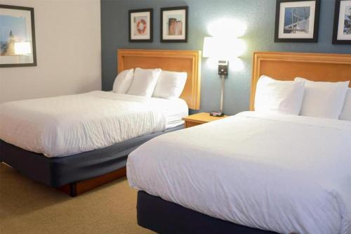 a hotel room with two beds with white sheets at Harbor Town Inn, BW Signature Collection in Manitowoc